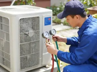 Technician checking refrigerant levels on an outdoor AC condenser unit