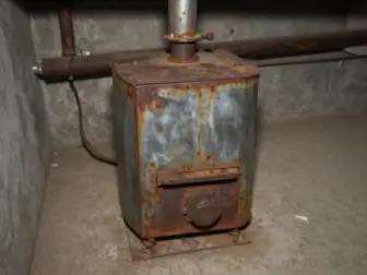 Old wall furnace with visible rust and damage before removal